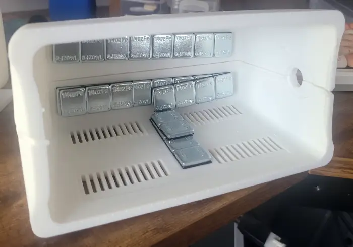 the hollow interior of the computer console, with wheel weights stuck on.