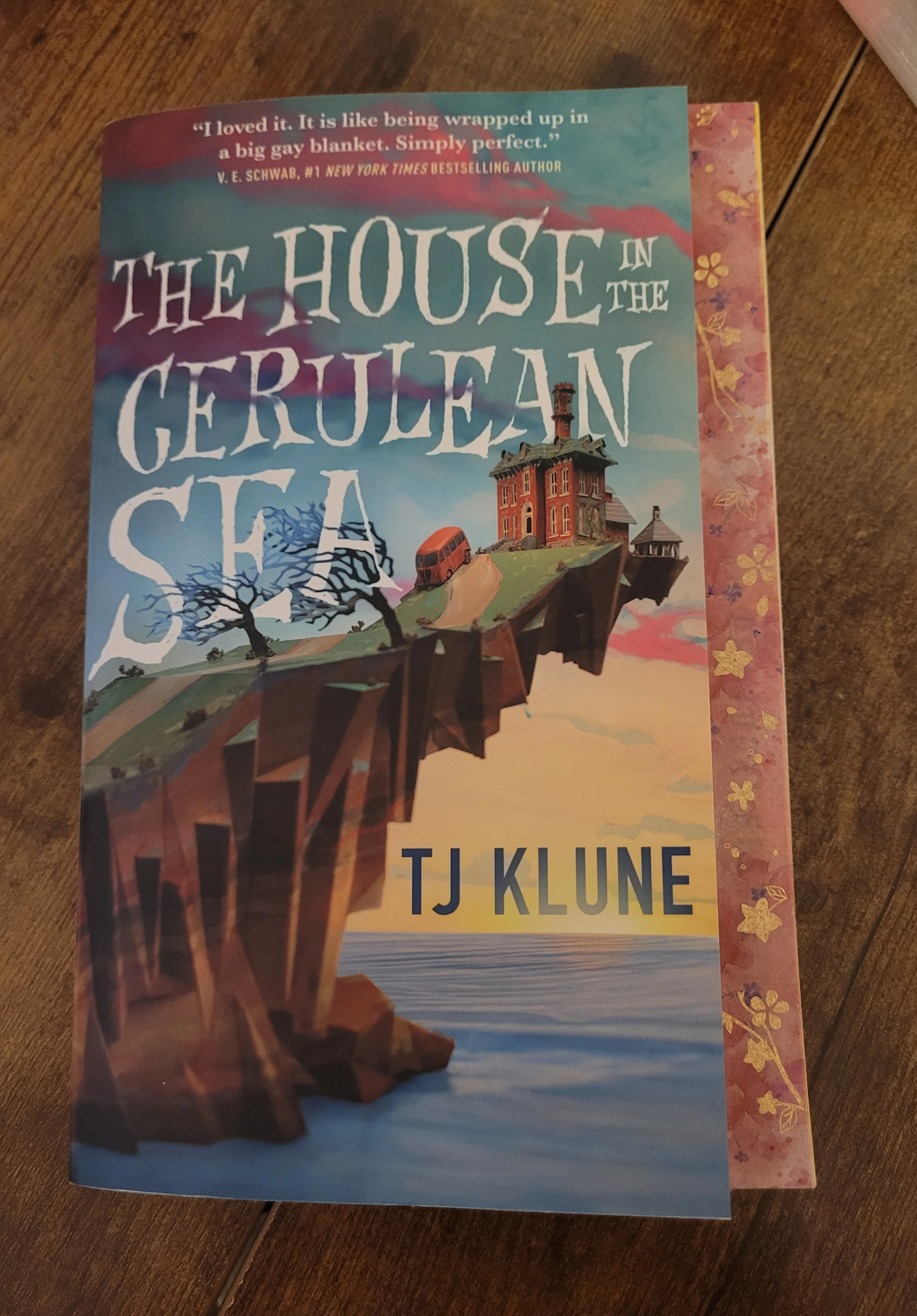 Front cover of The House in the Cerulean Sea with some gold and blush pink washi tape around it